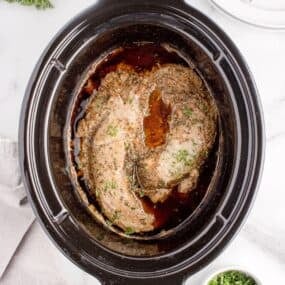 Cooked pork tenderloin in the crock pot insert.