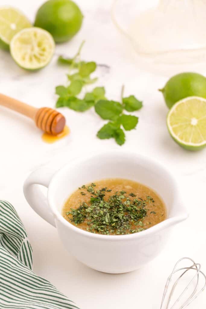 Fruit salad dressing in a little pouring cup.