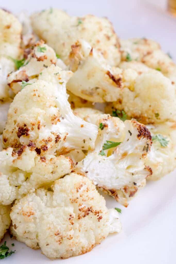 Cooked cauliflower on a white dinner plate.