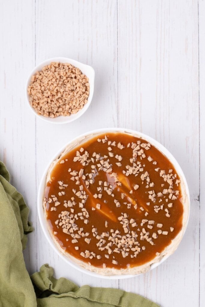 The caramel layer has been sprinkled with toffee bits, showing the completed caramel apple dip.
