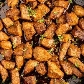 Completed steak bites in garlic butter.