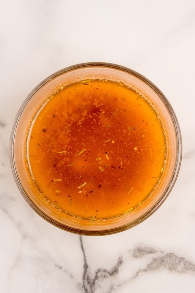 Dressing for roasted baby carrots in a small glass jar.