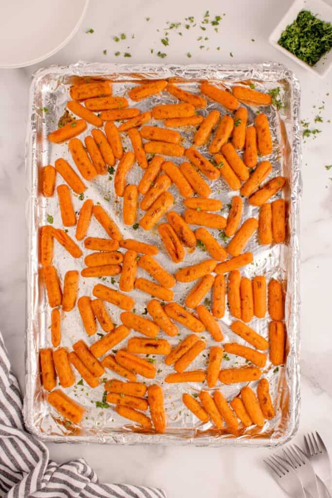 Aluminum lined baking sheet with roasted baby carrots.