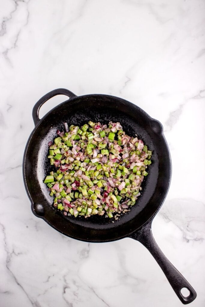 Cast iron pan with sauteed chopped celery, onion, garlic, sage, rosemary, salt, and pepper.