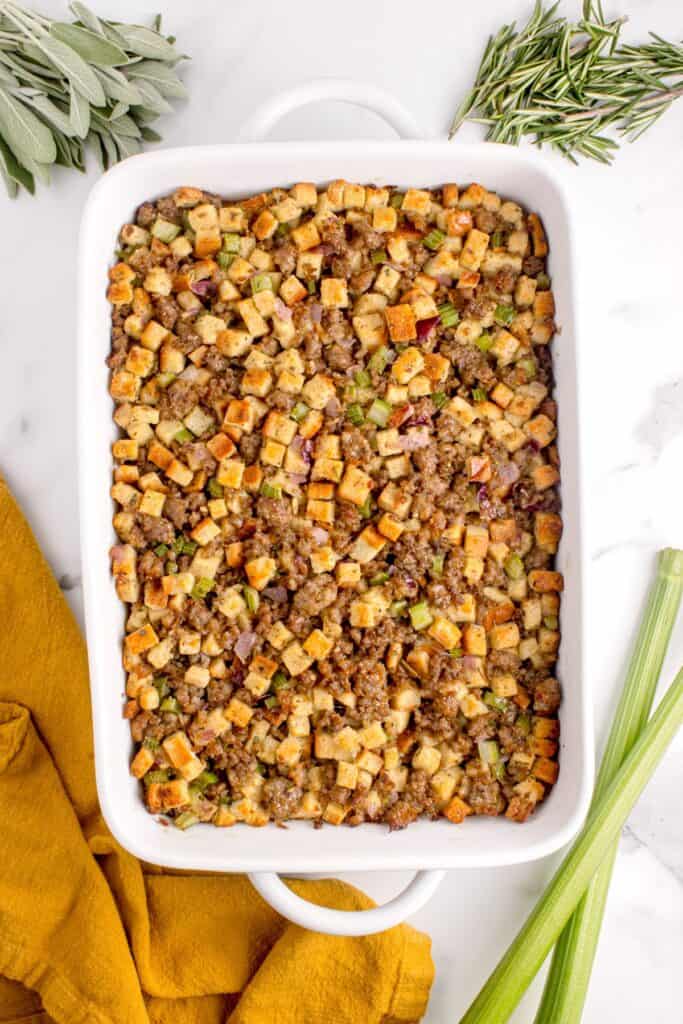 A white baking dish with completed sage and sausage stuffing in it.