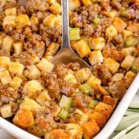 A white baking dish with completed sage and sausage stuffing in it.