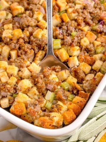 A white baking dish with completed sage and sausage stuffing in it.