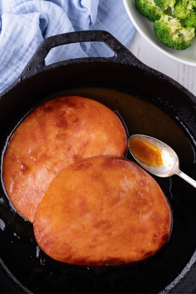 Ham steaks cooked in a cast iron pan.