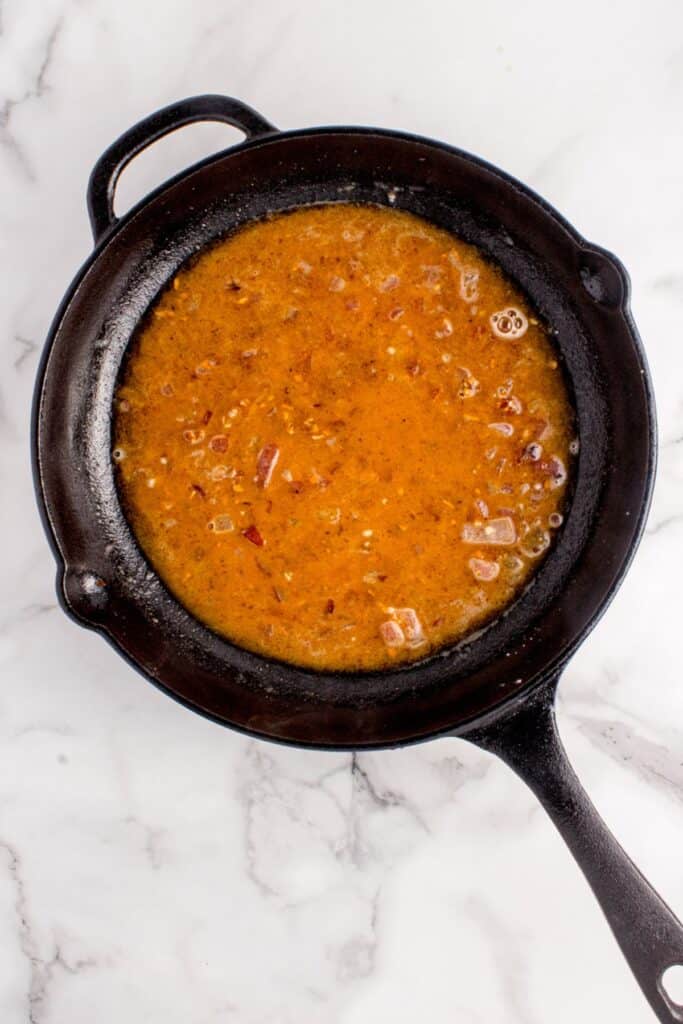 Broth added to onion and bacon mixture.
