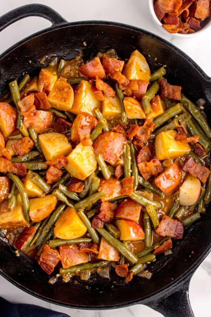 Completed green bean recipe in a cast iron pan.