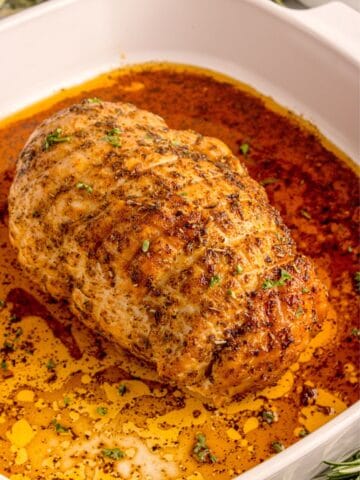 White square baking dish with cooked turkey breast.