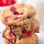 A stack of four cherry cookies on a marble counter.