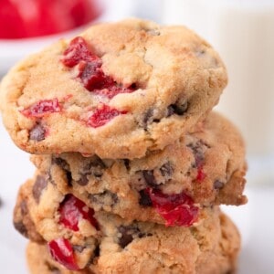 A stack of four cherry cookies on a marble counter.