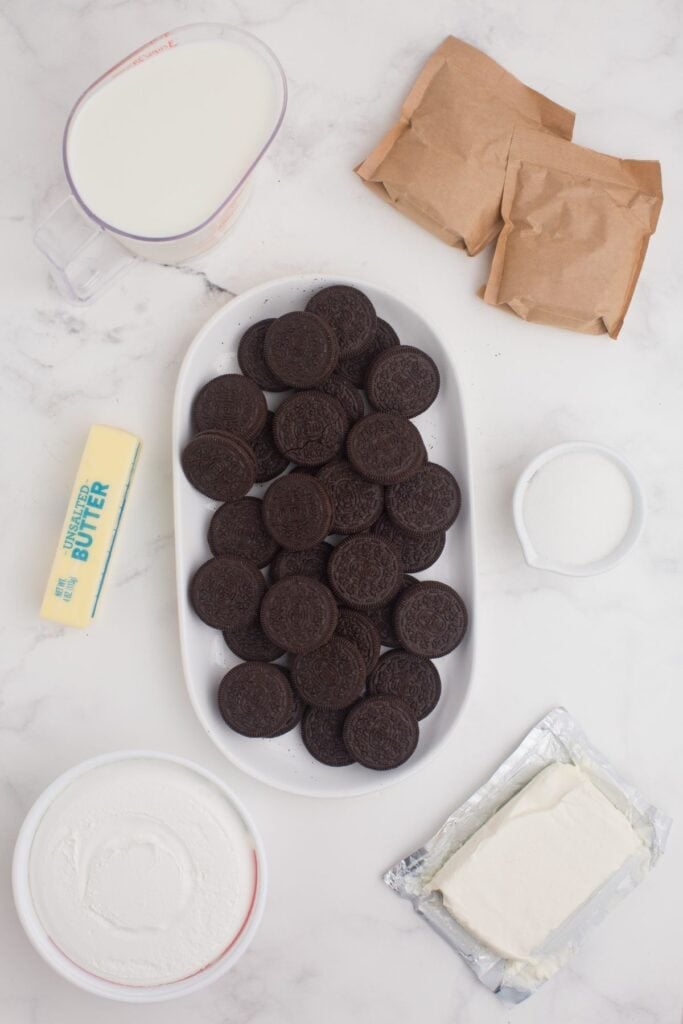 Ingredients for chocolate lasagna: Oreo cookies, unsalted butter, cream cheese, sugar, cool whip, instant chocolate pudding mix, and cold milk.