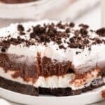 Piece of chocolate lasagna on a small white plate. A fork has removed a bite to show the layers of the lasagna.