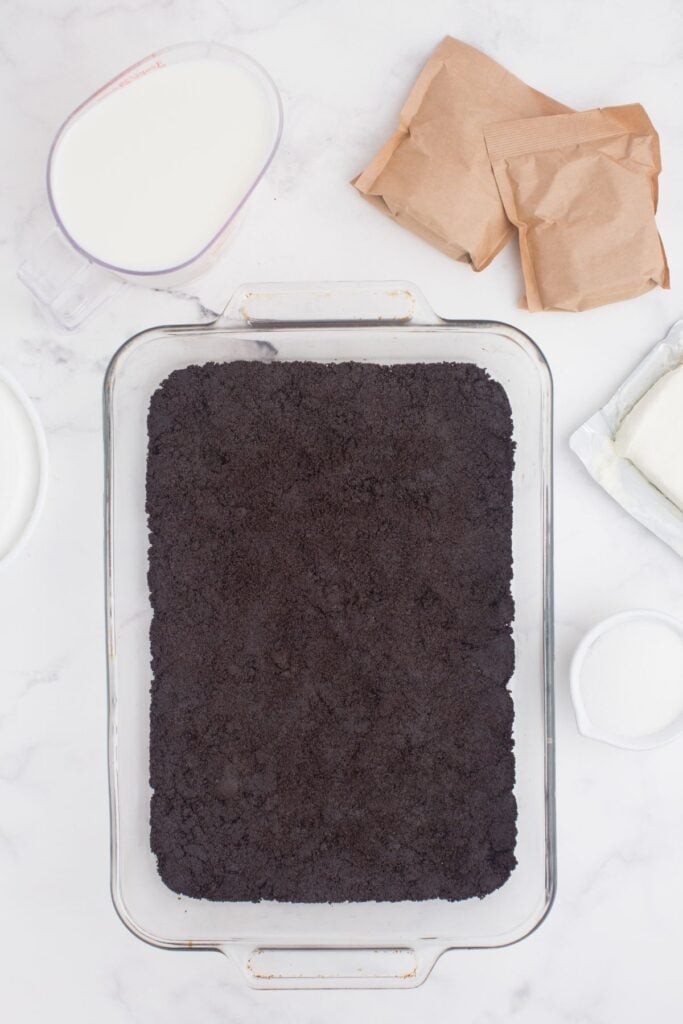 Oreo cookie crust pressed into the bottom of a 9x13 inch glass baking pan.