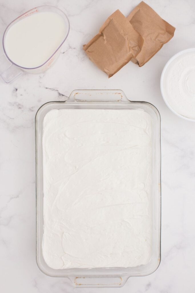 Cream cheese mixture is spread into an even layer over the cookie crust.