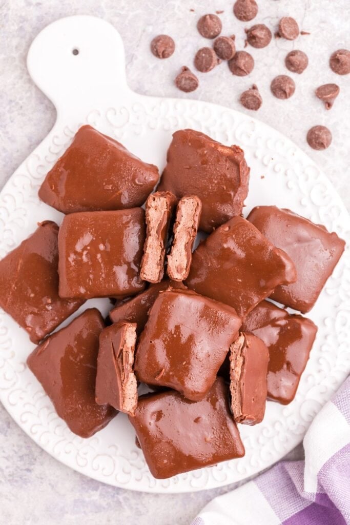 Completed Cool Whip candy piled up on a white serving platter. Two pieces are cut in half to show cross section.