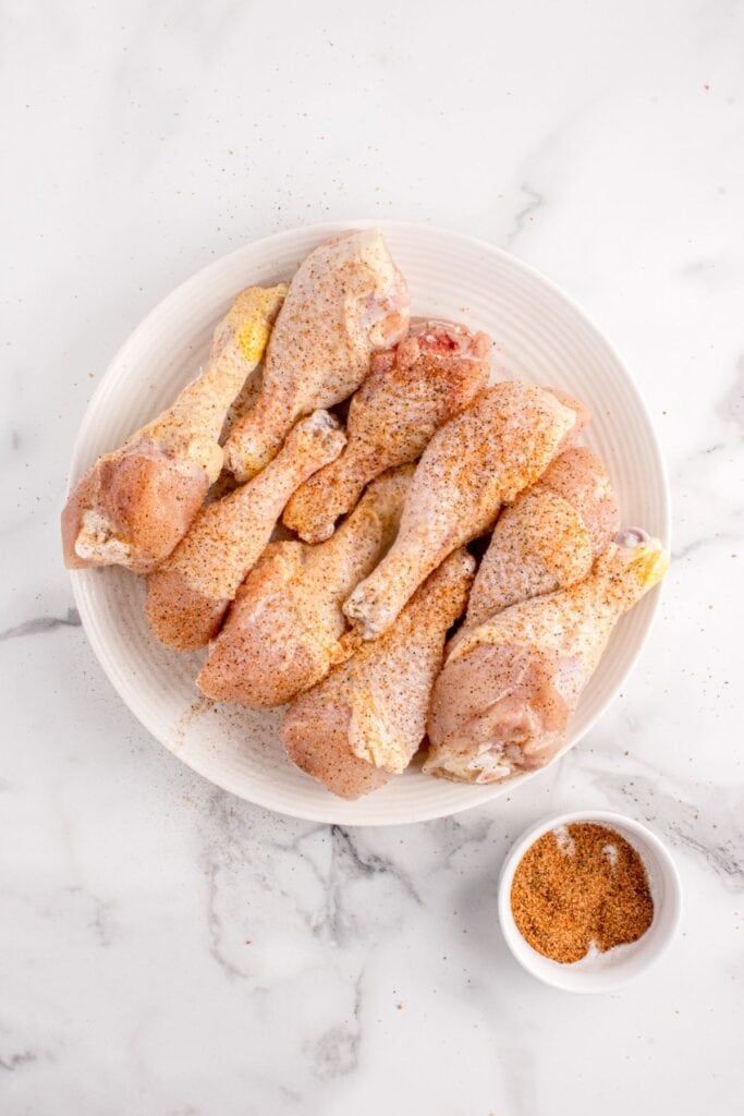 Chicken legs lightly drizzled in olive oil and sprinkled with seasoning.