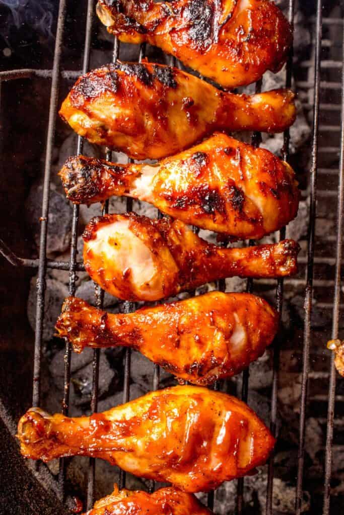 Chicken legs cooking on the grill.
