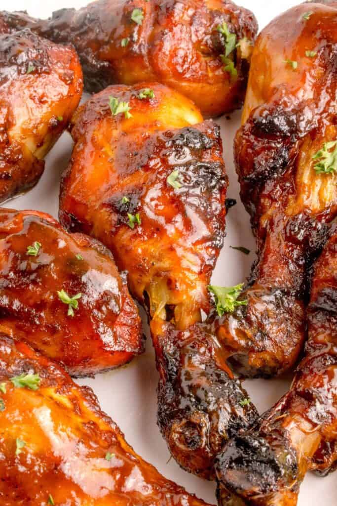 Finished grilled chicken legs on a white dinner plate.