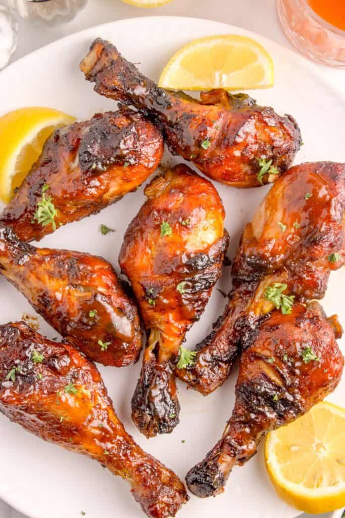 Grilled chicken legs on a white dinner plate.