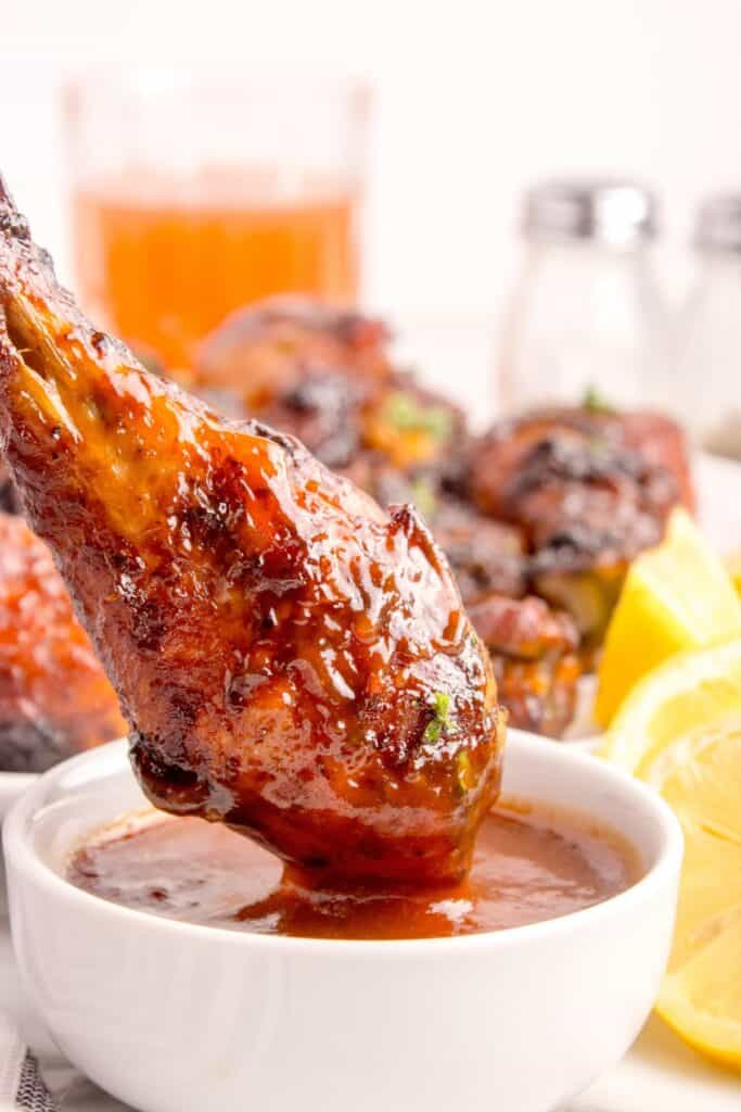 Grilled chicken legs dipped in BBQ sauce.
