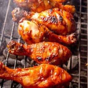 Chicken legs on a charcoal grill.