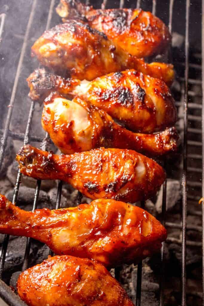 Chicken legs on a charcoal grill.