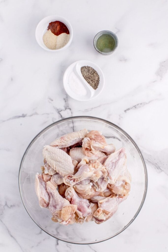 Ingredients for grilled chicken wings: whole chicken wings, garlic powder, onion powder, smoked paprika, salt, black pepper, cayenne pepper, and olive oil.