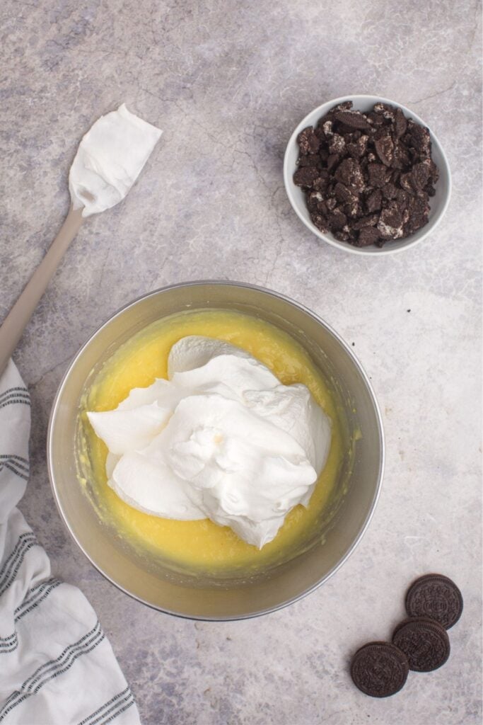 Cool Whip added to the mixing bowl with vanilla pudding.