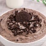 Oreo fluff in a white bowl with crushed Oreos on top.