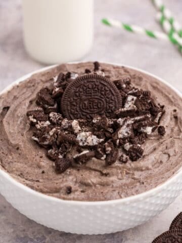 Oreo fluff in a white bowl with crushed Oreos on top.