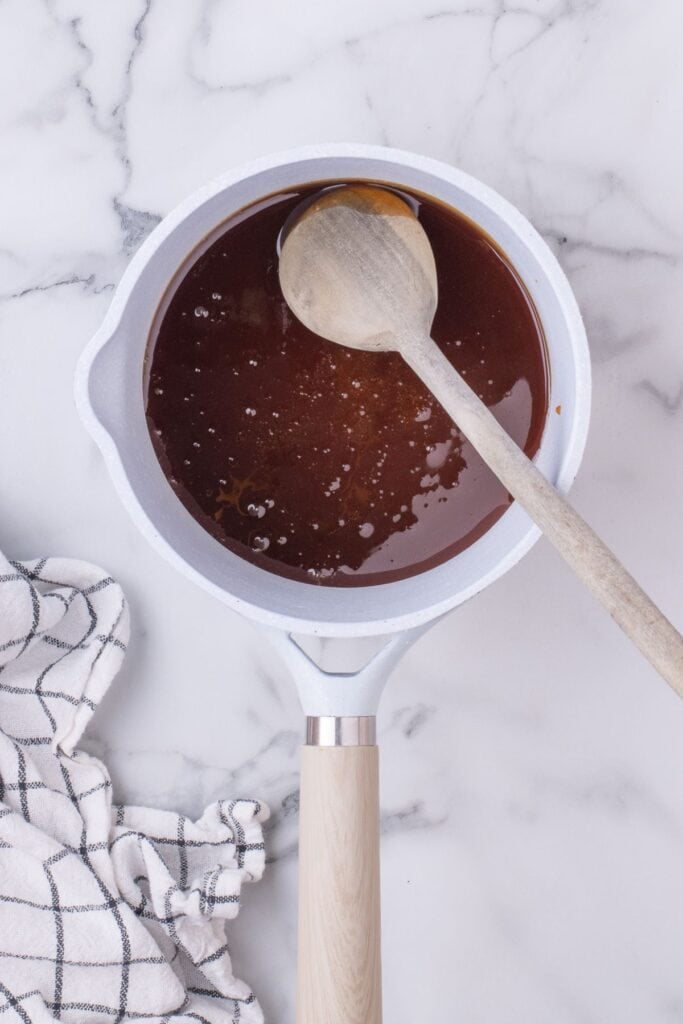 Ham glaze reducing in a sauce pot.