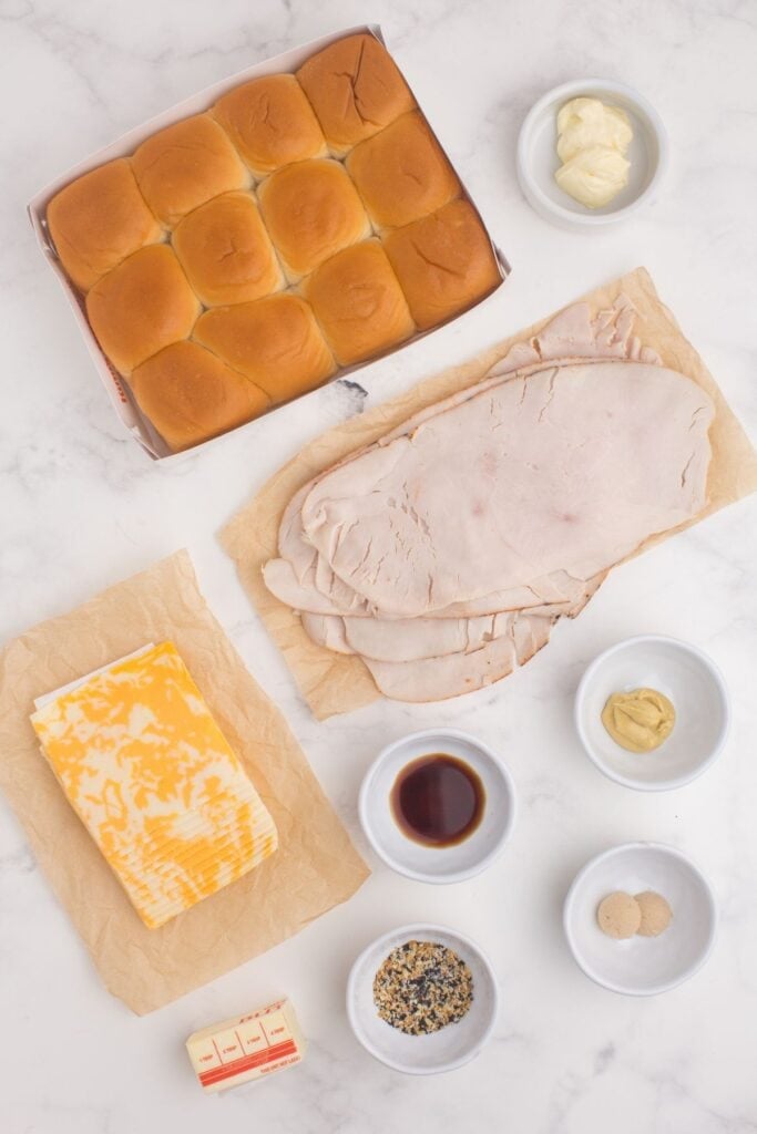 Ingredients for turkey sliders: Kings Hawaiian Rolls, mayonnaise, turkey, cheddar cheese, unsalted butter, Dijon mustard, light brown sugar, worcestershire, and everything seasoning.