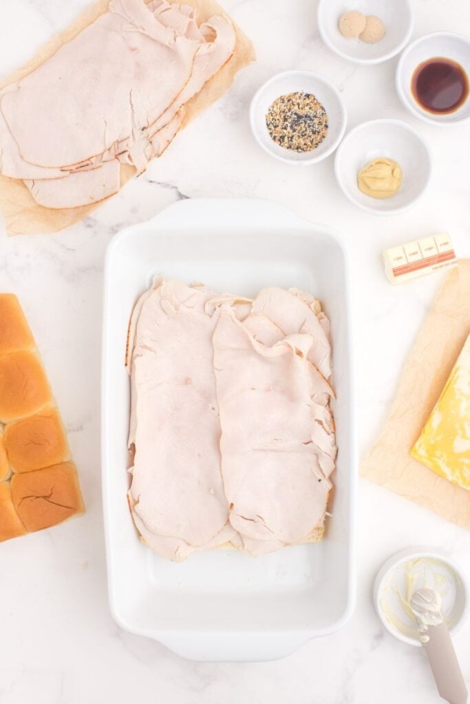 A layer of turkey is added to the bread and mayo sandwich base.