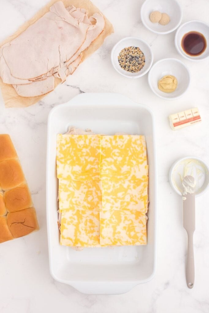 A layer of colby jack cheese is added to the sandwiches.