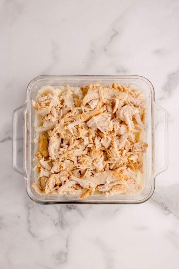 Cooked and shredded turkey layered on mashed potato layer.