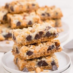 Stack of three 7 layer bars on a white plate.