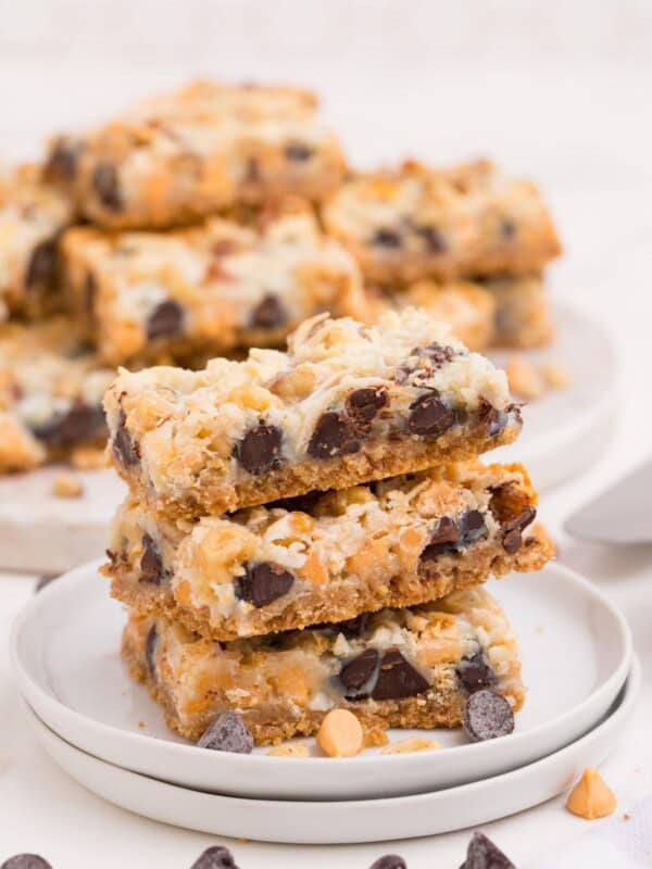 Stack of three 7 layer bars on a white plate.
