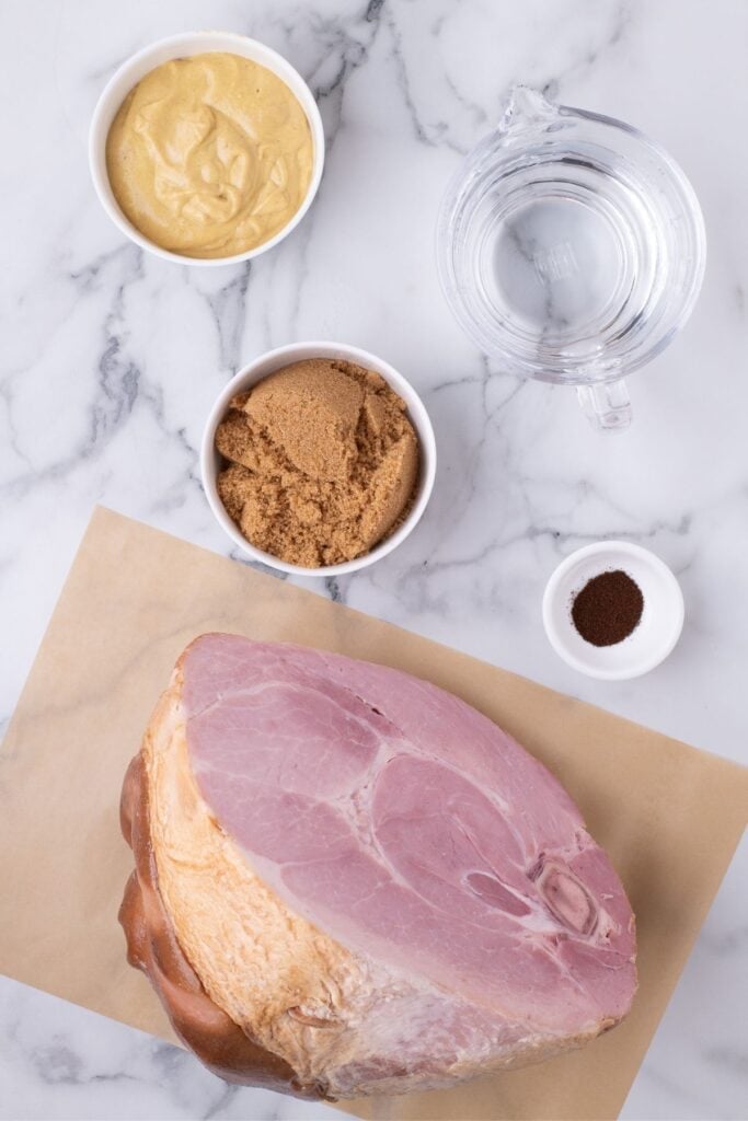 Ingredients for ham shank: large unsliced ham, mustard, brown sugar, water, and ground cloves.