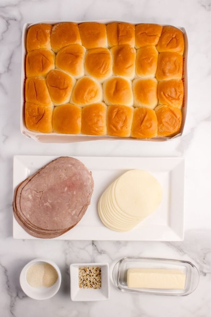 Ingredients for roast beef sliders: Hawaiian Sweet Rolls, Deli sliced roast beef, Deli sliced provolone cheese, unsalted butter, onion powder, garlic powder, and everything bagel seasoning.