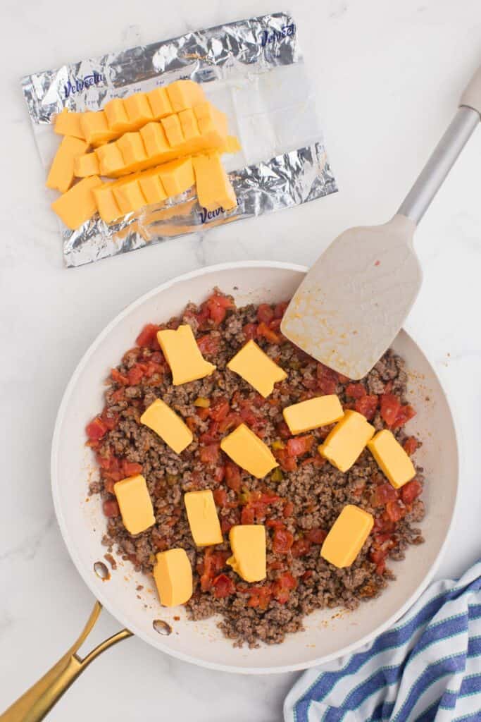 Melt chunks of Velveeta cheese in the ground beef and Rotel mixture.