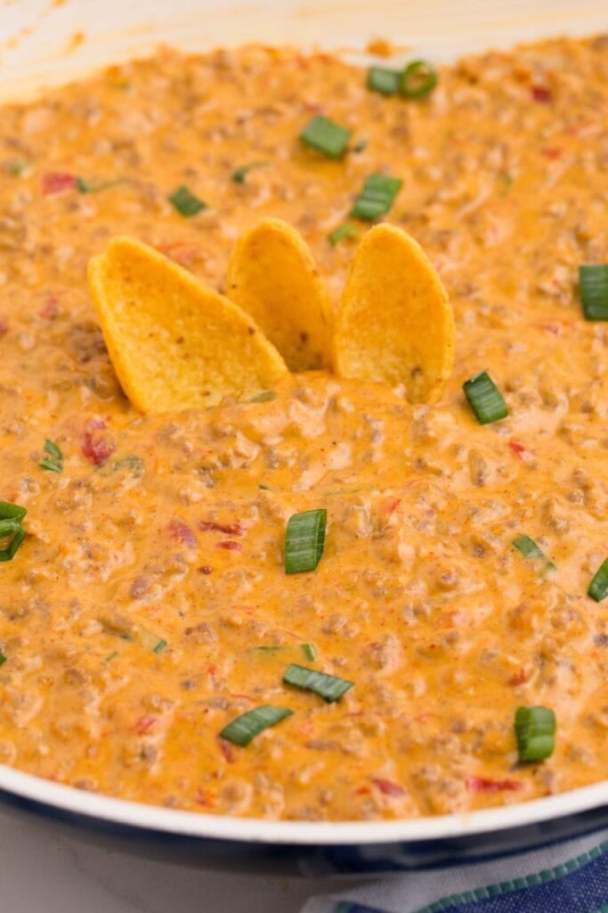 Cheese dip with three corn chips stuck in it.