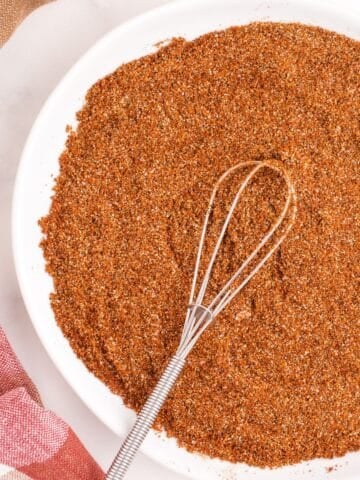 A white serving bowl with chili seasoning in it.