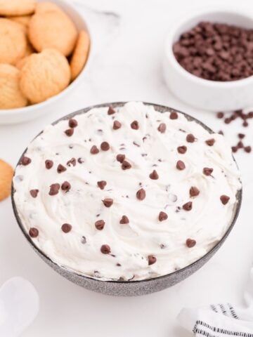A bowl of completed cookie dough dip with sprinkled chocolate chips on top.