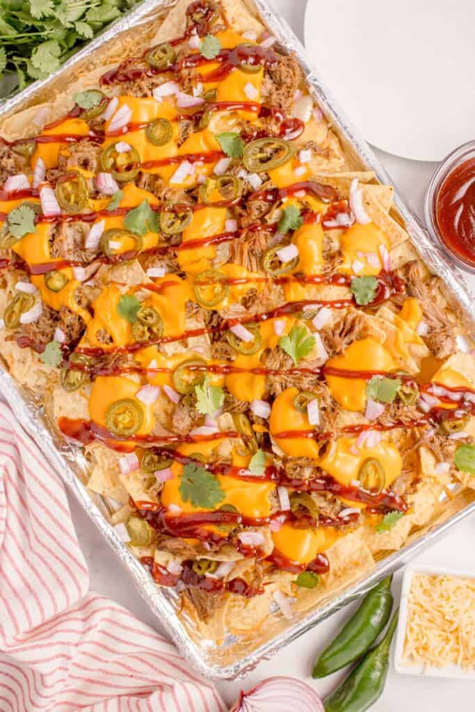 Easy pulled pork nachos on a baking sheet.