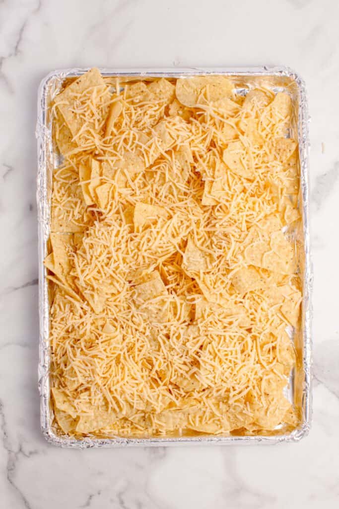 Tortilla chips with shredded cheese sprinkled on top.