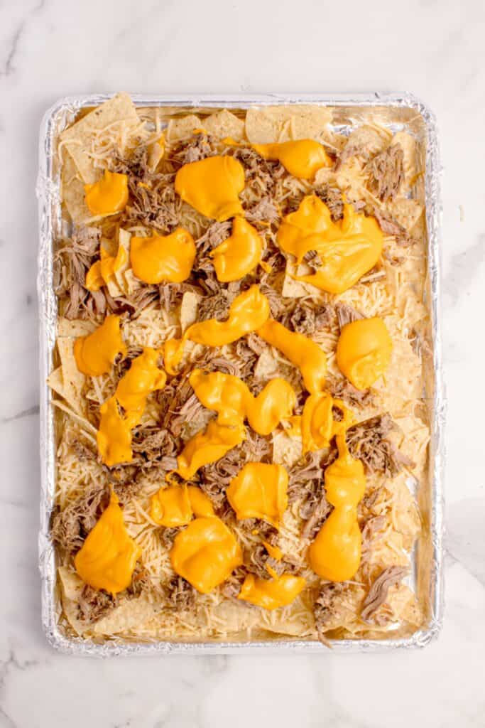 Nachos topped with warmed nacho cheese.