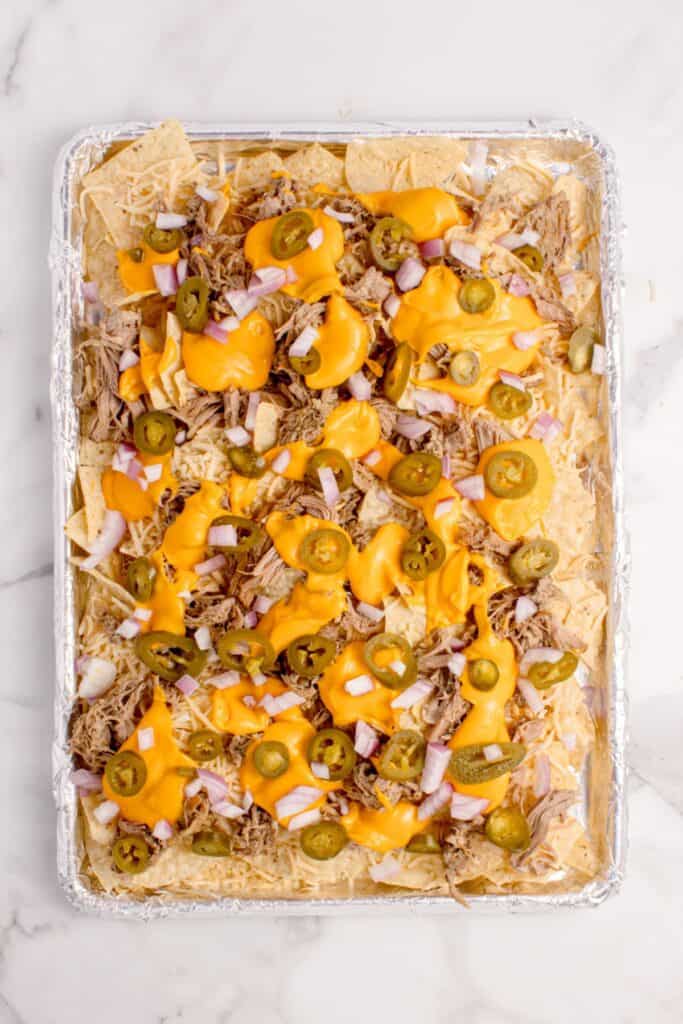 Nachos topped with picked jalapenos and diced red onion.